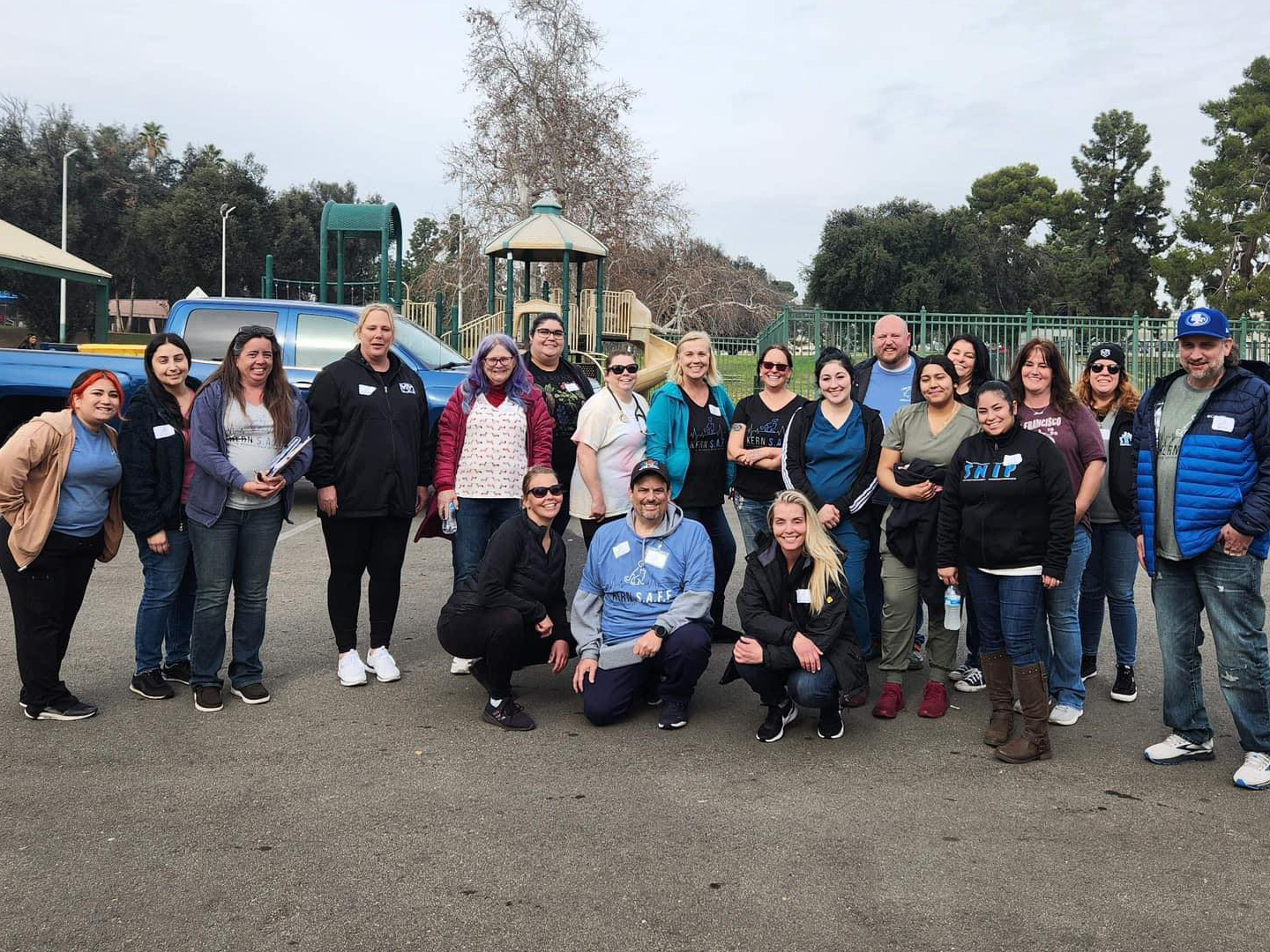 Kern S.A.F.E. coalition members and volunteers stand together under a cloudy sky